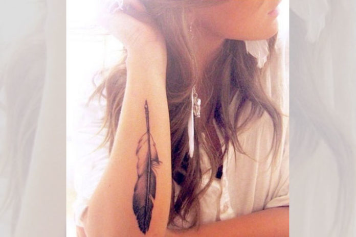 Elbow pointing feather tattoo