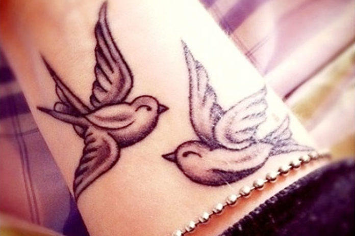 Two birds on wrist tattoos