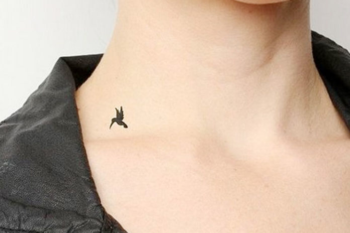 Small black bird tattoo on neck